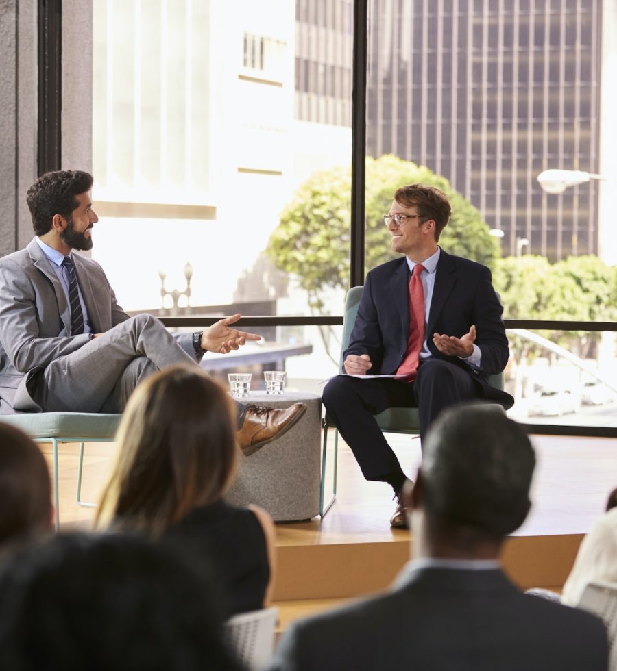 speaker-and-interviewer-talk-in-front-of-audience-at-seminar.jpg